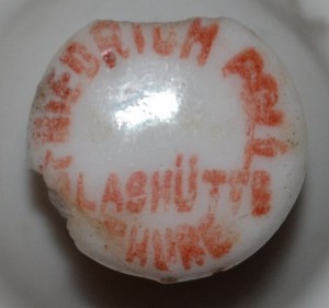 Powiększenie porcelanowej stopki korka z napisem: FRIEDRICH POLL/ GLASHÜTTE/ THURE