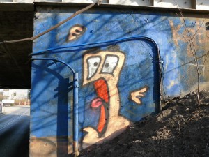 Czy widoczny krzyk (przerażenie) postaci ze ściany sprowokuje kierowcę do odpowiedniej reakcji, zanim zatrzyma się na wiadukcie? Na zdjęciu widoczne też są ślady dotychczasowych kolizji – liczne zarysowania stropu wiaduktu   fot. Piotr P. Ruszkowski