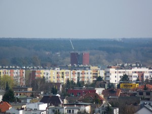 Zdjęcie wykonane z wieży kościoła św. Barbary. Widać, jak charakterystyczny dla Lubonia przez lata silos dominuje nad dachami zabudowy jednorodzinnej i blokowej. Kiedy demontaż zagrażał bezpieczeństwu pracowników, użyto dźwigu – dużo wyższego od silosu. Na jego ramieniu podwieszono kosz ze spawaczem (w czerwonej kamizelce), który, zaczynając od szczytu, palnikiem rozcinał elementy   fot. Rafał Wojtyniak