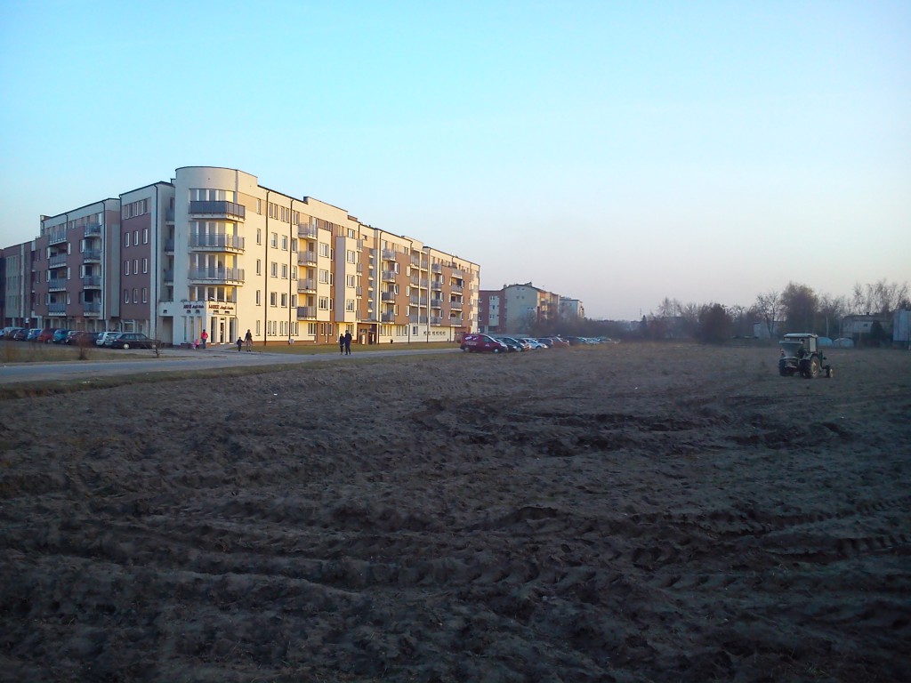 Tu, gdzie ma być przedszkole dla Nowego Centrum Lubonia (NCL), traktor rozsiewa nawozy. Obok – osiedlowe życie na ul. Kochanowskiego i A. Mizerki   fot. B. Stempczyńska