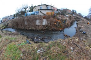 Po wycięciu krzewów i drzew ujawnia się stan skarp. Widok przy ul. Tuwima, z lewej nad ciekiem widać mostek, którym ścieżka rowerowa przejdzie na drugą stronę wzdłuż cieku przy ul. Strumykowej   fot. Piotr P. Ruszkowski