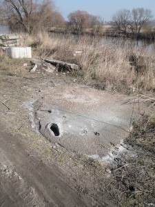 Resztki betonu wylane nad Wartą i porzucone tam odpady z prefabrykatów