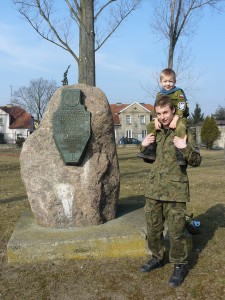 Następne pokolenie rośnie. Na ramionach Oskara Frankowskiego najmłodszy Strzelec – Adrian Kołcz – przed stosownym obeliskiem z treścią: „ŻOŁNIERZOM/ PODZIEMNEGO/ PAŃSTWA POLSKIEGO/ II WOJNY ŚWIATOWEJ/ ZNIEWOLONYM/ W OKRESIE/ STALINOWSKIM/ W LATACH 1939-1956/ W HOŁDZIE/ KOMBATANCI/ ARMII KRAJOWEJ/ OKRĘG/ WIELKOPOLSKA/ 1990   fot. Paweł Wolniewicz